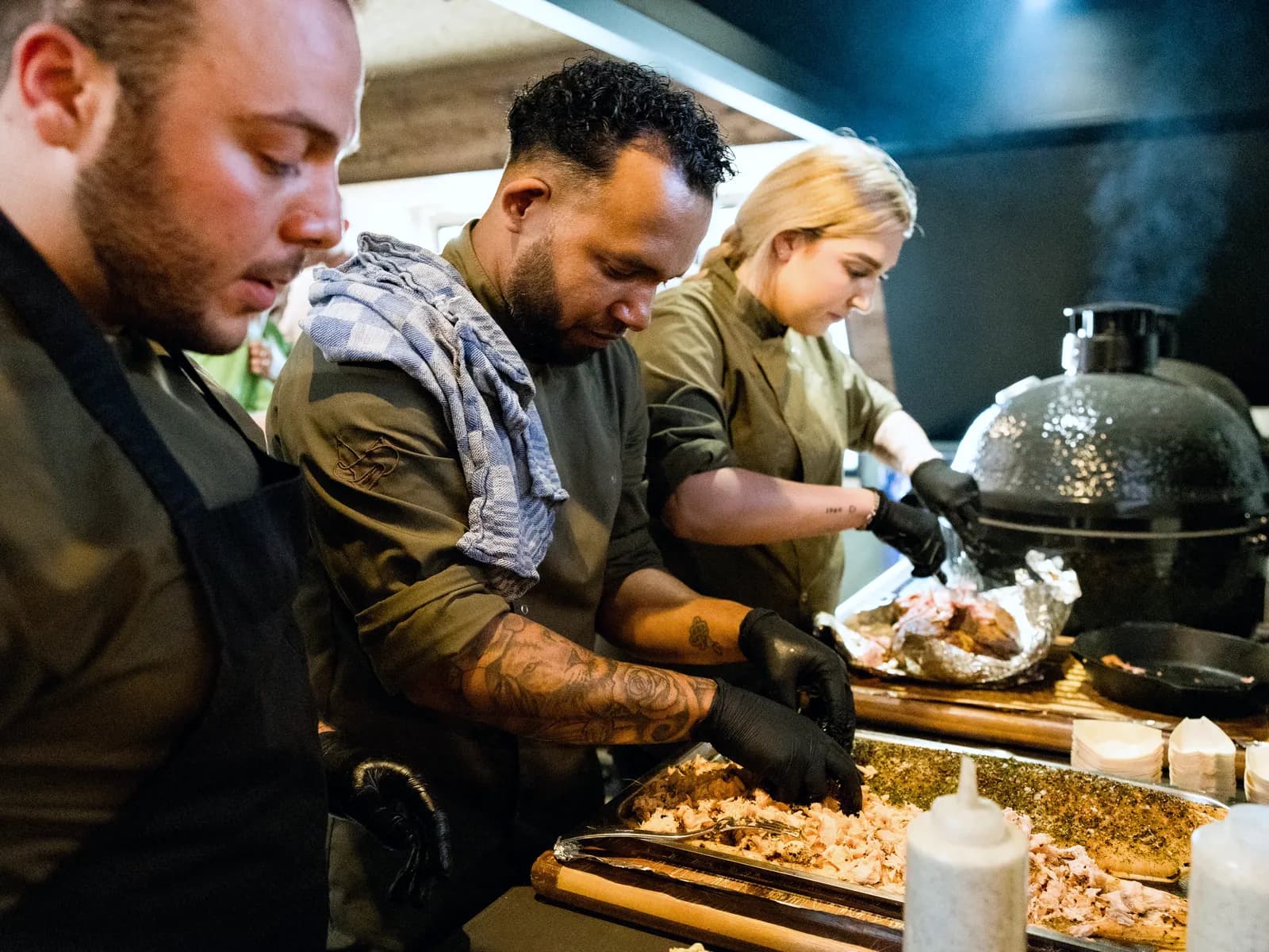 Koks trekken vers gegrild vlees naast de kamado tijdens live cooking