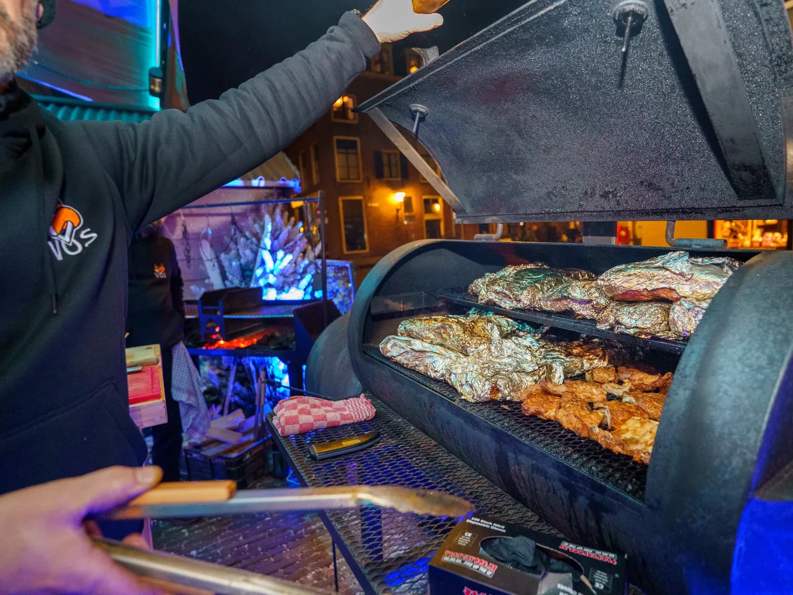 Kok haalt gegrild vlees uit de smoker tijdens live cooking bij De Haas