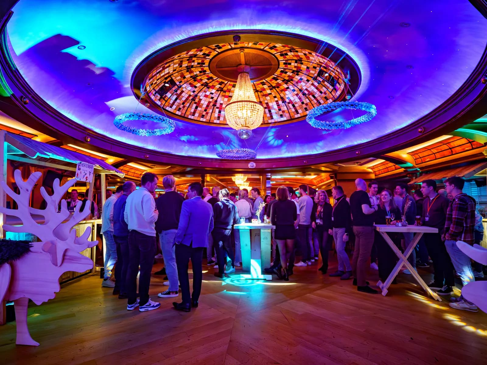 Personeelsfeest onder de verlichte glas-in-loodkoepel van de Sterrenzaal bij De Haas