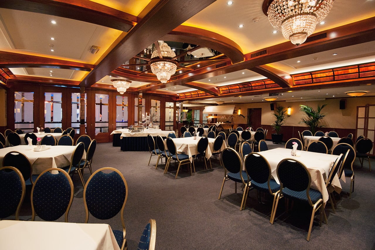 Pauwzaal met gedekte tafels en kroonluchters
