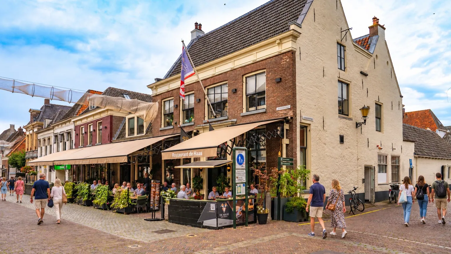De Jufferenstraat in Elburg met het zonnige terras van De Haas en de Vischpoort aan het eind van de straat