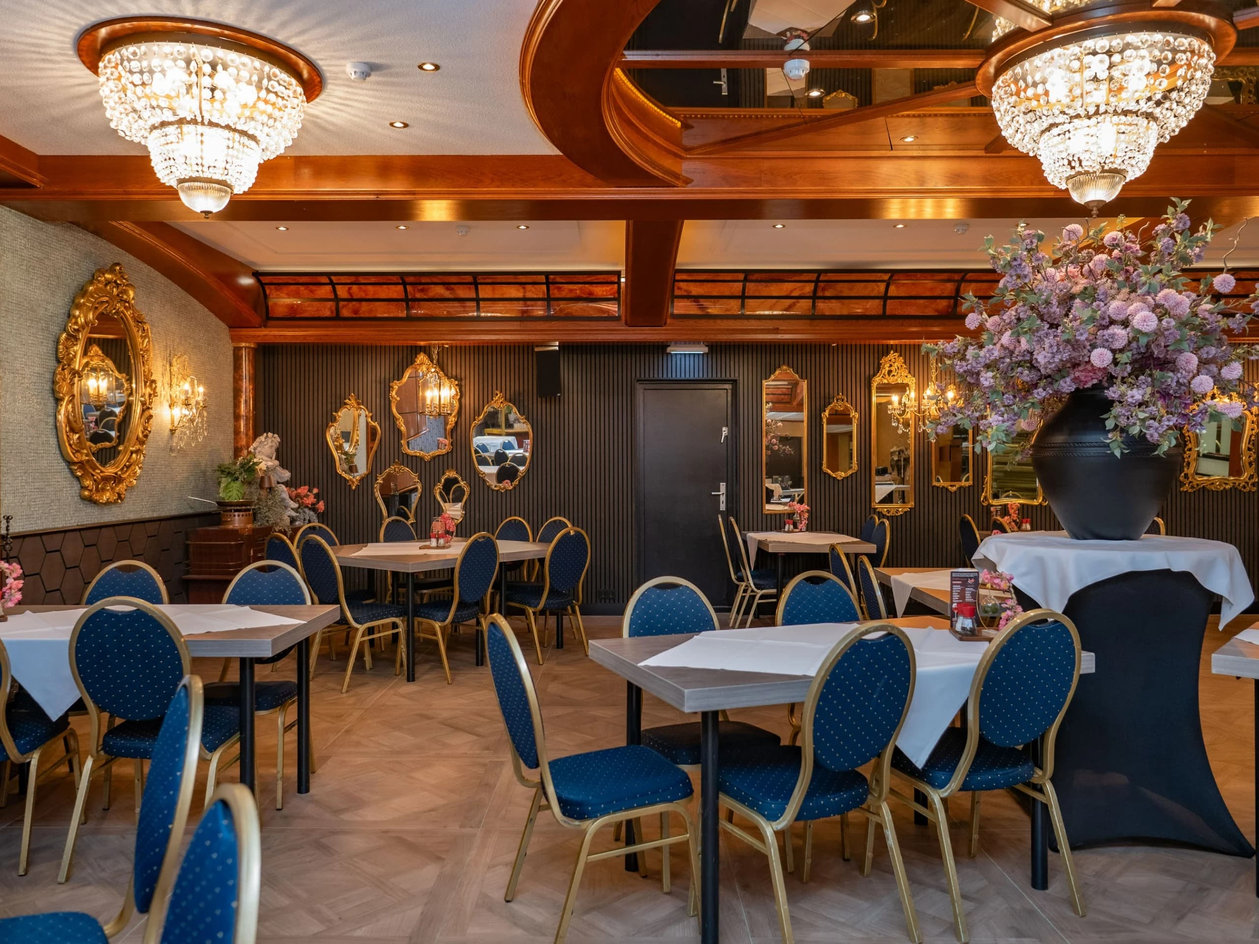 Pauwzaal met gedekte tafels en kroonluchters